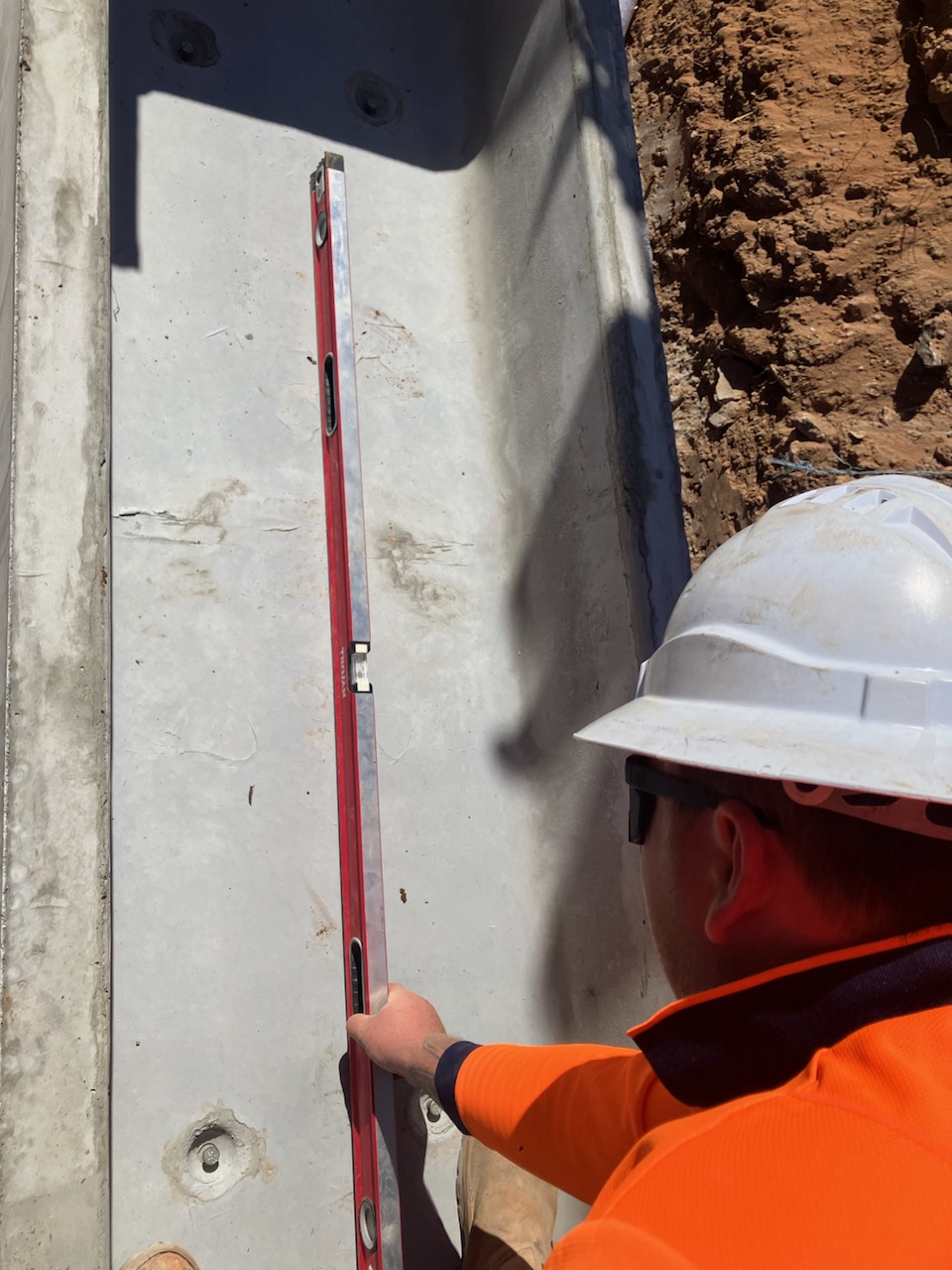 Worker checking level on a precast culvert